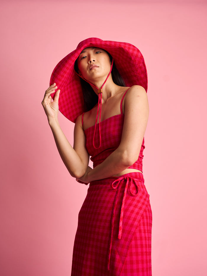 The Lucie Marquis 'Dylan Sunhat' is a wide brimmed sun hat with heavy topstitching and a wooden block cord end. Inspired by the iconic spirit of Bob Dylan and the bold essence of Georgia O'Keeffe, the sun hat embodies timeless style with a subtle nod to the 70s and a touch of cowboy charm. Perfect for shielding from the sun, it's the ideal accessory for your travel adventures.