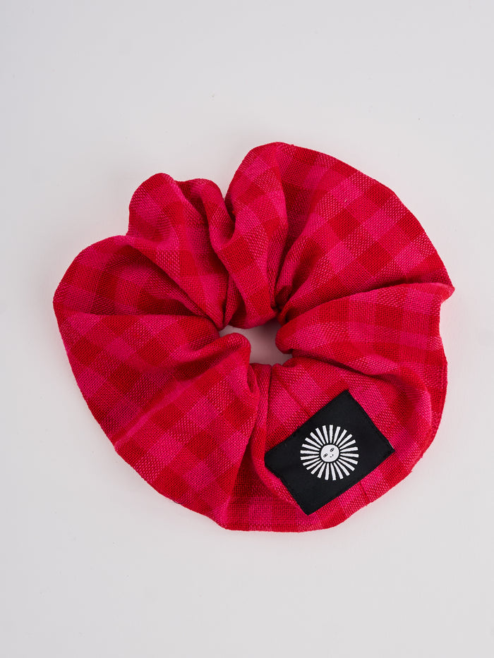 The Lucie Marquis 'Susie Scrunchie' is a stylish oversized hair scrunchie made from leftover fabric scraps. The scrunchie is 7cm wide and designed to wrap around twice. It features a brand label stitched flat on one side. The scrunchie effortlessly elevates any outfit. A great travel accessory, sustainably made.