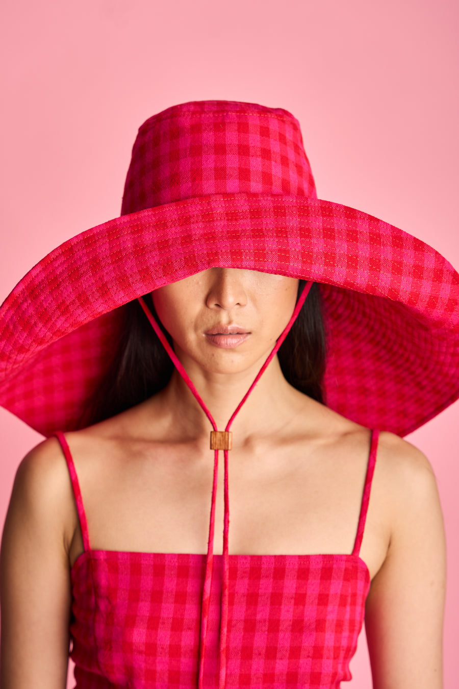 The Lucie Marquis 'Dylan Sunhat' is a wide brimmed sun hat with heavy topstitching and a wooden block cord end. Inspired by the iconic spirit of Bob Dylan and the bold essence of Georgia O'Keeffe, the sun hat embodies timeless style with a subtle nod to the 70s and a touch of cowboy charm. Perfect for shielding from the sun, it's the ideal accessory for your travel adventures.