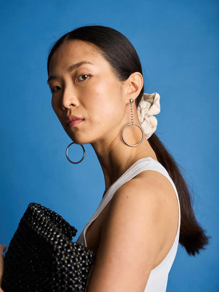 The Lucie Marquis 'Susie Scrunchie' is a stylish oversized hair scrunchie made from leftover fabric scraps. The scrunchie is 7cm wide and designed to wrap around twice. It features a brand label stitched flat on one side. The scrunchie effortlessly elevates any outfit. A great travel accessory, sustainably made.