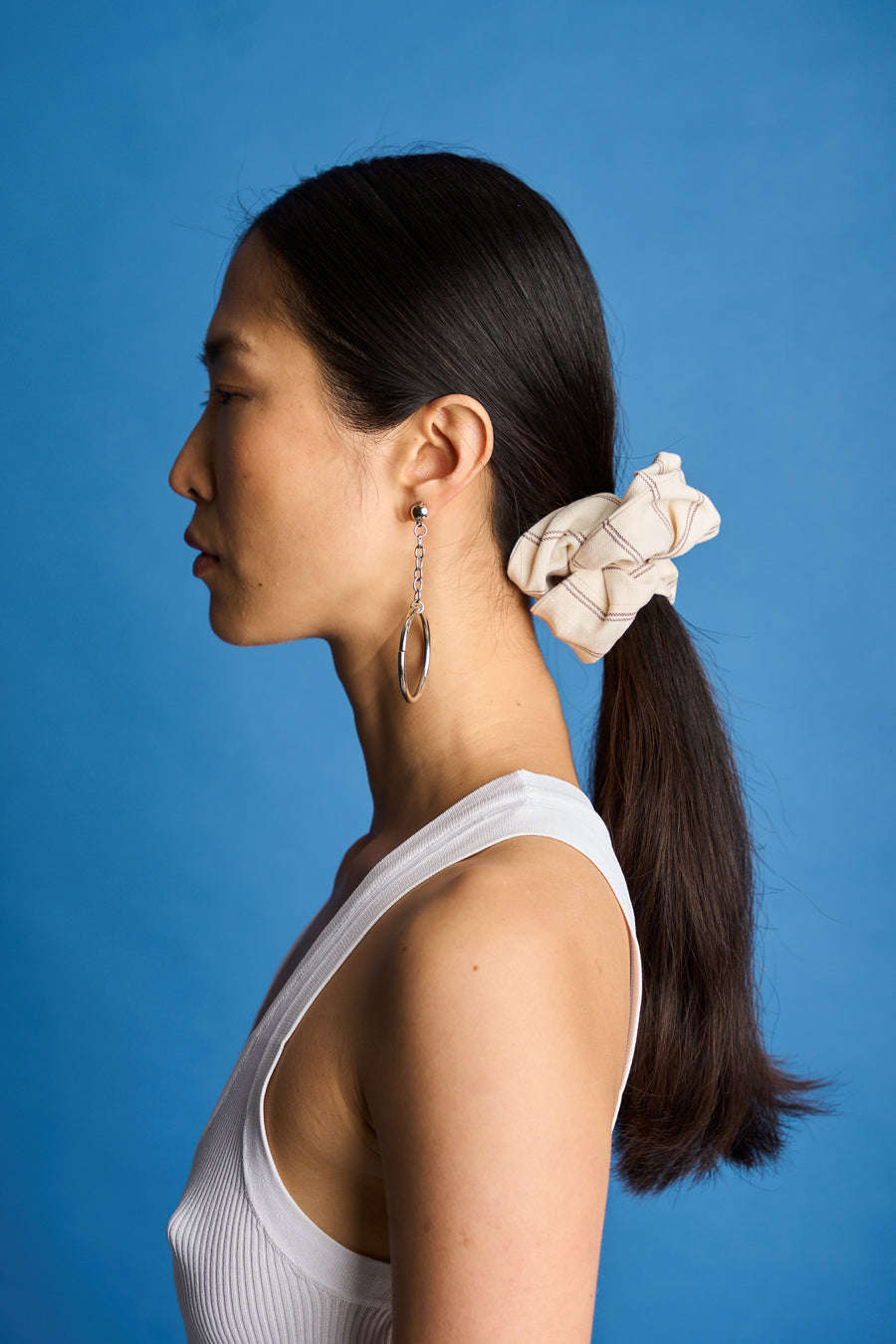 The Lucie Marquis 'Susie Scrunchie' is a stylish oversized hair scrunchie made from leftover fabric scraps. The scrunchie is 7cm wide and designed to wrap around twice. It features a brand label stitched flat on one side. The scrunchie effortlessly elevates any outfit. A great travel accessory, sustainably made.