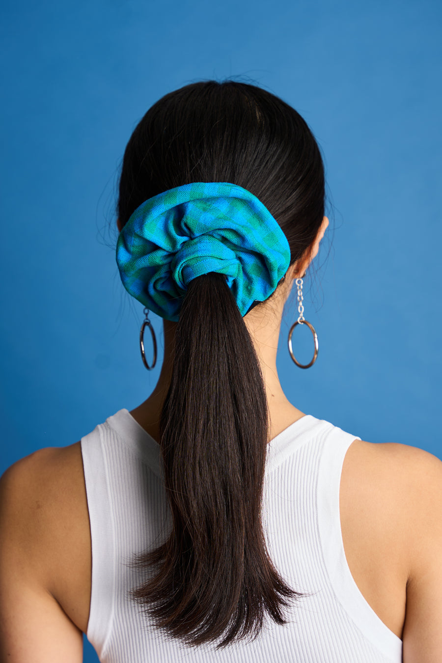 The Lucie Marquis 'Susie Scrunchie' is a stylish oversized hair scrunchie made from leftover fabric scraps. The scrunchie is 7cm wide and designed to wrap around twice. It features a brand label stitched flat on one side. The scrunchie effortlessly elevates any outfit. A great travel accessory, sustainably made.